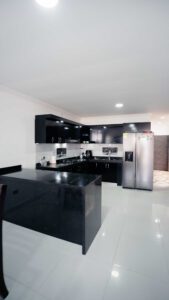 Cocina integral en negro y blanco con barra en mármol en la casa de lujo de Portal del Mirador.