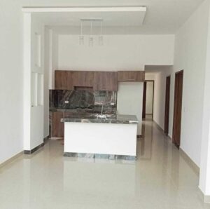 Sala y cocina moderna de casa nueva en Florencia CA, ubicada en Villas de San Pablo.